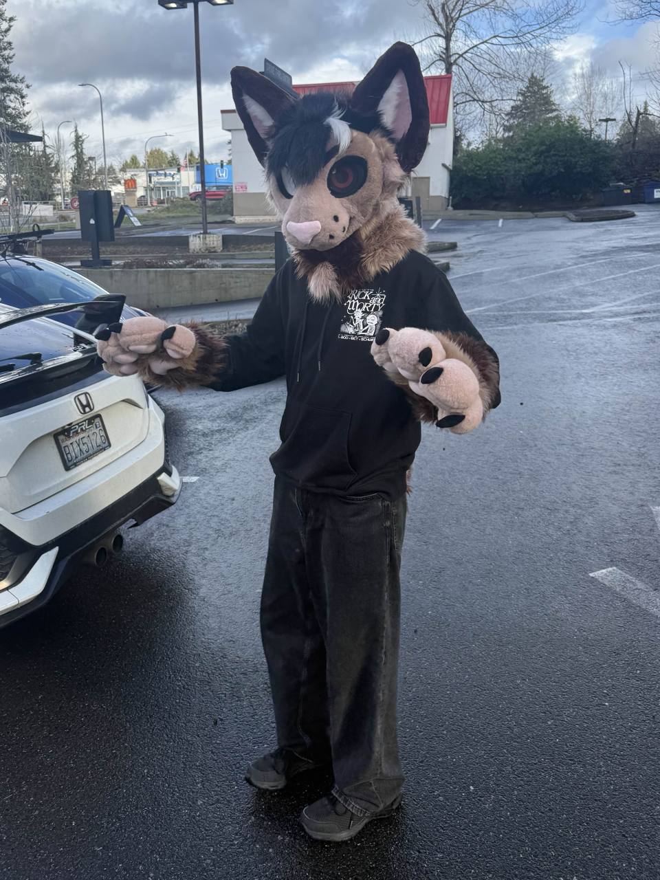 KeetSilco standing outside in suit on a wet street