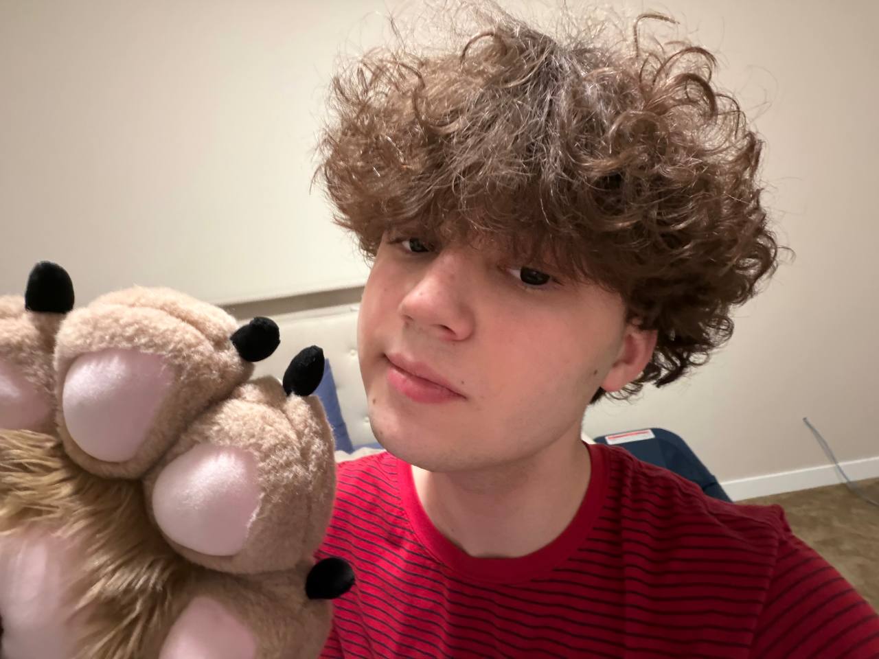 A face photo of KeetSilco with a suit paw held up near the camera